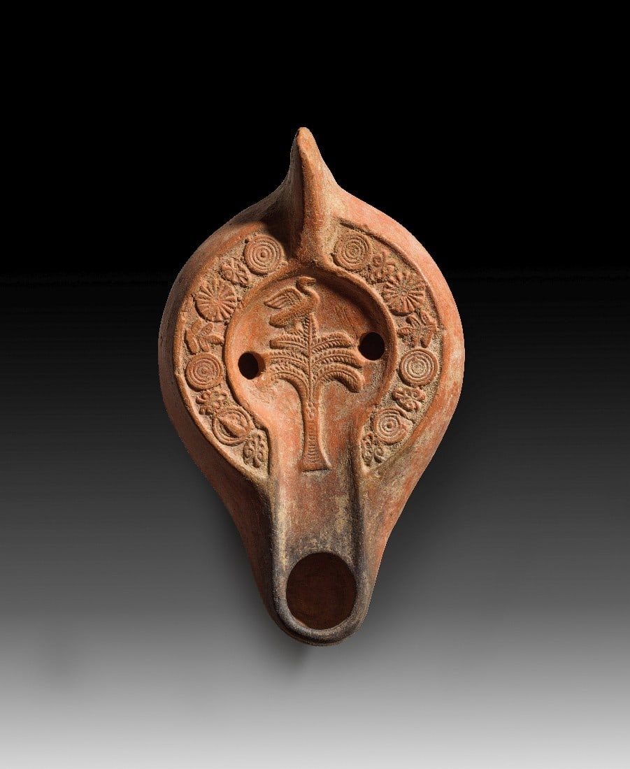 Spätantike Tonlampe mit Dattelpalme und Schwan.: Spätantike Tonlampe mit Dattelpalme und Schwan. Nordafrika, 4. - 5. Jh. n. Chr. Typ Hayes II. L 15cm, H 5,5cm. Aus hellrotem Ton mit rotem Überzug. Zapfenförmiger Griff, eiförmiger Corpus,