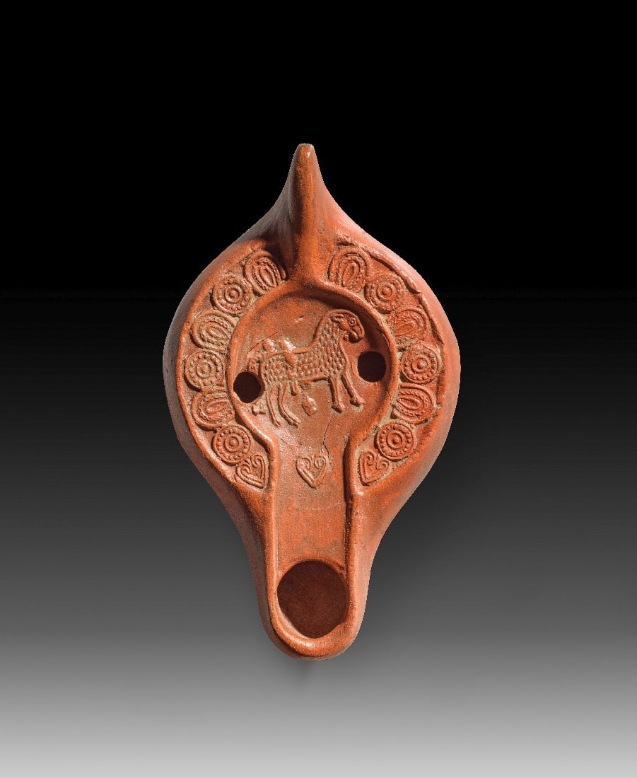 Spätantike Tonlampe mit Lamm Gottes.: Spätantike Tonlampe mit Lamm Gottes. Nordafrika, 4. - 5. Jh. n. Chr. L 14,4cm, ø 8,3cm. Hayes II. Auf der Schulter Hufeisen, Kreise mit eingestellten Punkten und Efeublättern. Spiegel gebrochen und