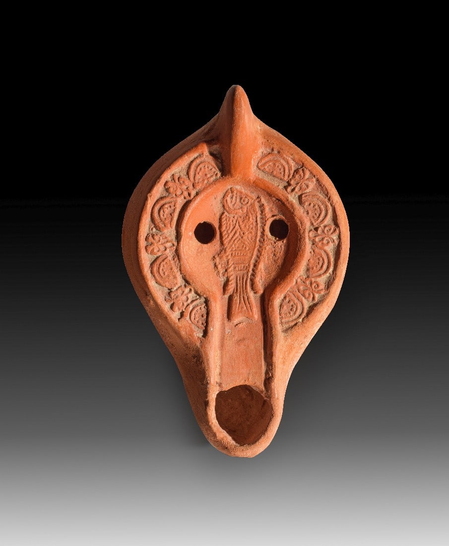 Spätantike Tonlampe mit Fisch als christliches Symbol.: Spätantike Tonlampe mit Fisch als christliches Symbol. Nordafrika, 4. - 5. Jh. n. Chr. L 11cm, ø 6,8cm. Hayes II. Auf der Schulter Halbkreise und Palmetten. Intakt. Provenienz: Ex Privatsammlung
