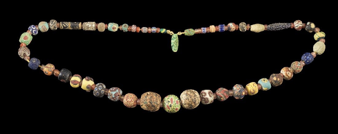 Halskette mit Millefiori-Glasperlen.: Halskette mit Millefiori-Glasperlen. Römisch, 100 v. Chr. - islamisch, 1000 n. Chr. L ca. 96cm. Aus kugeligen und röhrenförmigen, mehrfarbigen Glasperlen mit verschiedenen Mustern. Dazwischen