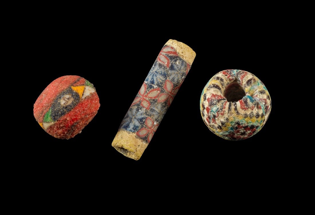 Sammlung polychrome Glasperlen.: Sammlung polychrome Glasperlen. Römisch, Alexandria, 300 v. Chr. - 100 n. Chr. a) ø 14,9mm. Kugelige Perle aus rotem Glas mit einem Schmuckband in der Mitte aus mehrfarbigen Rauten und anderen