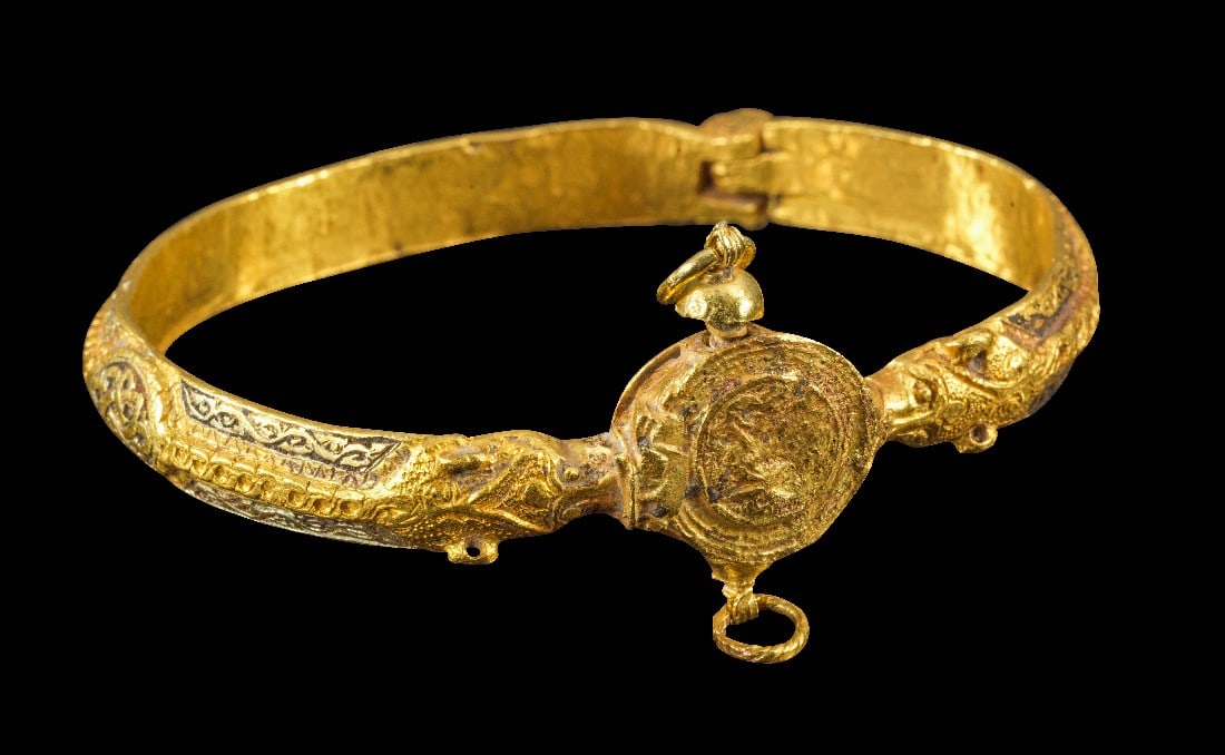 Goldarmreif mit reichem Dekor.: Goldarmreif mit reichem Dekor. Islamisch, 13. Jh. n. Chr. 63,74g, ø 6,7cm. Mit Scharnier und einem Schraubverschluss. Der Reif dekoriert mit Flechtband und floralen Ranken mit Nielo-Einlagen, im