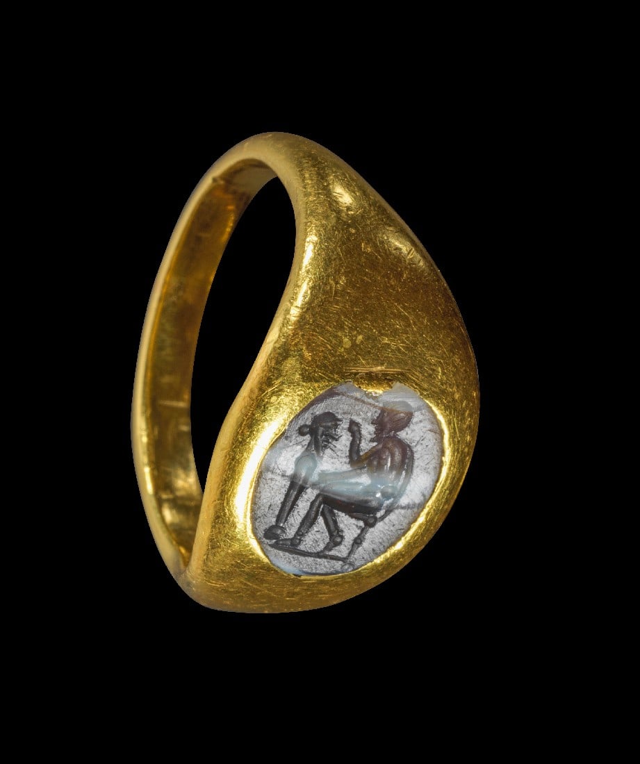 Goldring mit gestreiftem Achat mit Hermenbildhauer.: Goldring mit gestreiftem Achat mit Hermenbildhauer. Römisch, 1. - 2. Jh. n. Chr. 9,43g, Ringgröße 54-55. Goldring mit nach oben breiter werdender Schiene, auf der Platte eingelassen eine runde