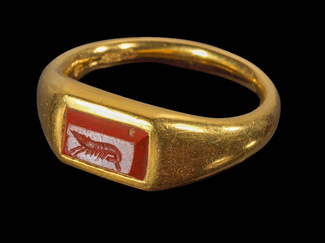 Moderner Goldring mit Jaspisgemme mit Garnele.: Moderner Goldring mit Jaspisgemme mit Garnele. Gemme römisch, 1. - 2. Jh. n. Chr. 16,99g, Ringgröße 59-60. Massiver Goldring mit nach oben breiter werdender Schiene. Auf der Platte eine