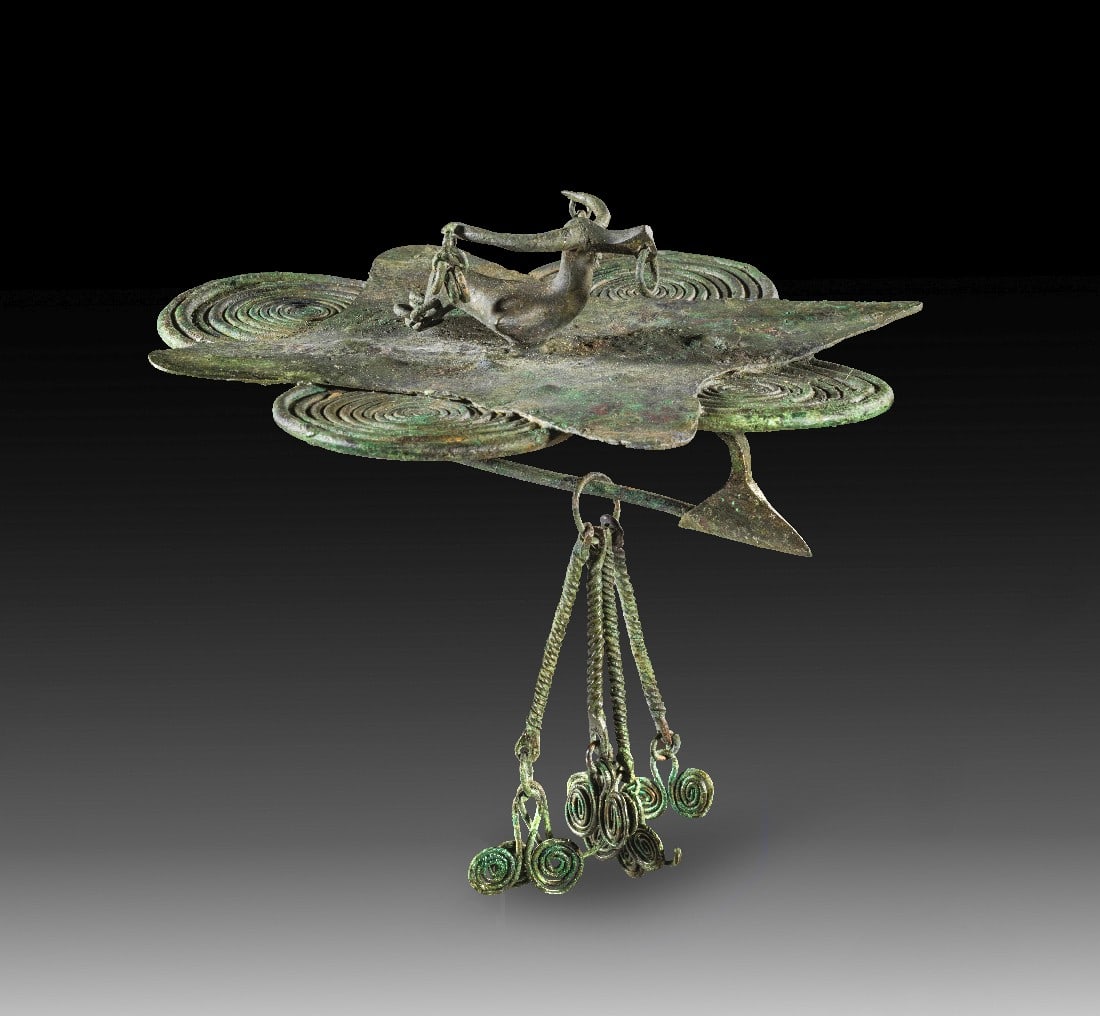 Bronzene Vierpassfibel.: Bronzene Vierpassfibel. Italisch, Kampanien?, 2. Hälfte 8. Jh. v. Chr. L 16,5cm. Fibel mit vier Spiralen. Auf der Unterseite eine einfache Bügelfibel mit Nadel, Nadelhalter und Anhänger mit