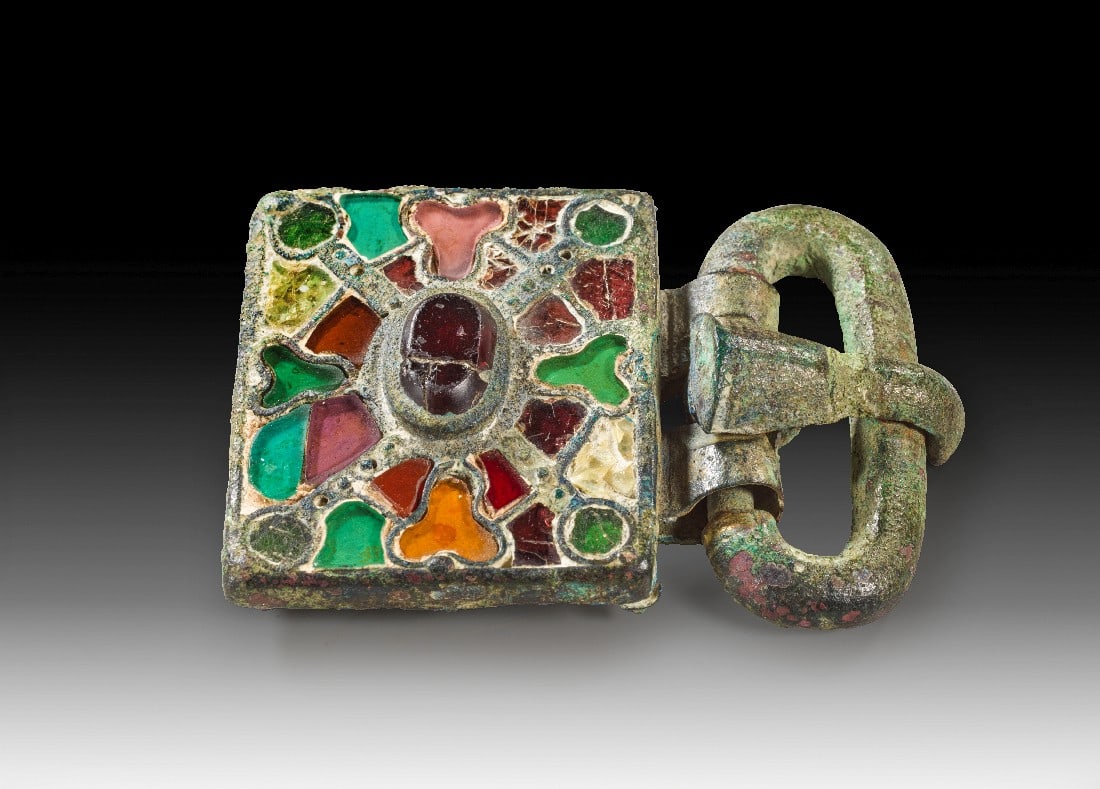 Bronzene Gürtelschnalle mit Glaseinlagen.: Bronzene Gürtelschnalle mit Glaseinlagen. Völkerwanderungszeit, westgotisch, 5. - 6. Jh. n. Chr. Gesamtlänge 7cm, Beschlag 4 x 4,7cm. Längsovale Schnalle mit gebogenem Dorn und rechteckigem