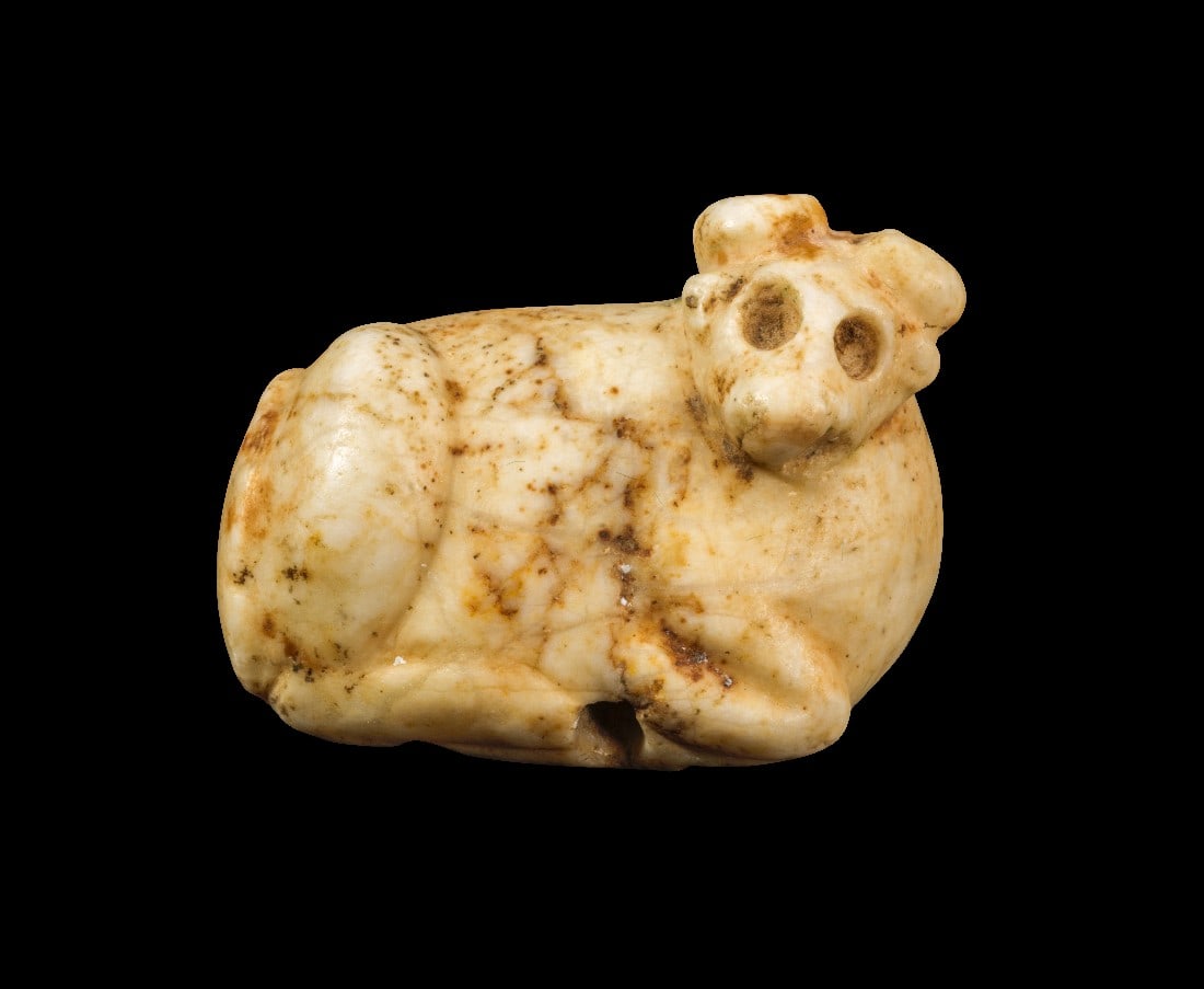 Amulett in Form eines Stieres.: Amulett in Form eines Stieres. Späte Uruk-Zeit, Djemdet Nasr-Periode, 3300 - 2900 v. Chr. B 3,5cm, H 2,5cm. Aus beigem Stein. Liegender Stier mit frontalem Kopf. Vertikale Bohrung. Auf der