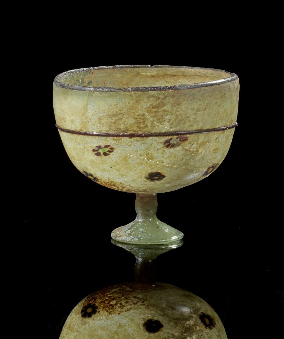 Islamischer Kelch mit Blumen.: Islamischer Kelch mit Blumen. H 9,2cm, ø 10,2cm. Halbkugeliger Kelch aus grünlichem Klarglas auf niedrigem Fuß mit mehrfarbigen Blumen auf der Außenseite. Auf der Lippe und an der Außenseite