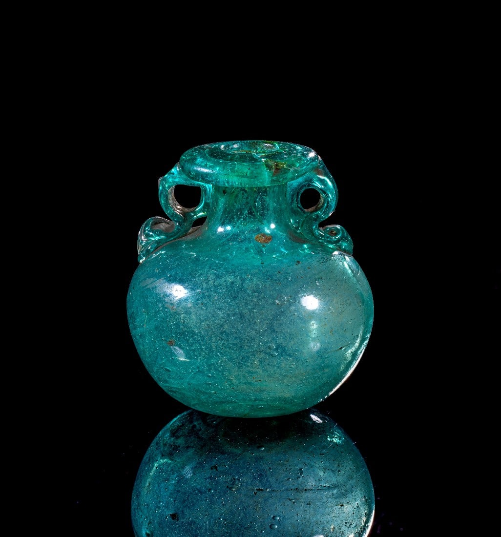 Aryballos.: Aryballos. Römisch, 1. Jh. n. Chr. H 6,1cm, ø Corpus 5,5cm. Aus grünem, transluzentem Klarglas. Bauchiger Corpus mit leicht nach innen gewölbtem Boden, kurzem, zylindrischem Hals und flachem,