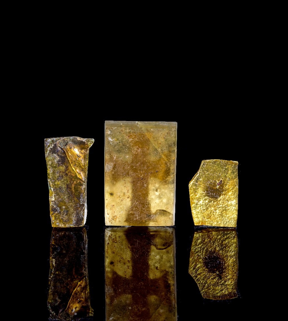 Sammlung Fragmente von Zwischengoldglas.: Sammlung Fragmente von Zwischengoldglas. Römisch, 4. Jh. n. Chr. a) H 3,5cm, B 2,5cm. Kreuz mit ausschwingenden Kreuzarmen aus Goldfolie zwischen Glas. b) H 3cm, B max. 1,7cm. Mit Resten eine