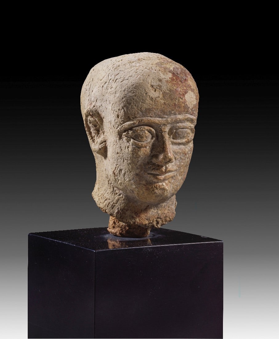 Terrakottakopf eines Priesters oder Königs.: Terrakottakopf eines Priesters oder Königs. Mesopotamien, Ur III, Neo-sumerisch, ca. 2112-2095 v. Chr. H 9,5cm, mit Sockel 20cm. Beige Terrakotta mit rotbraunem Überzug. Kahler Kopf mit