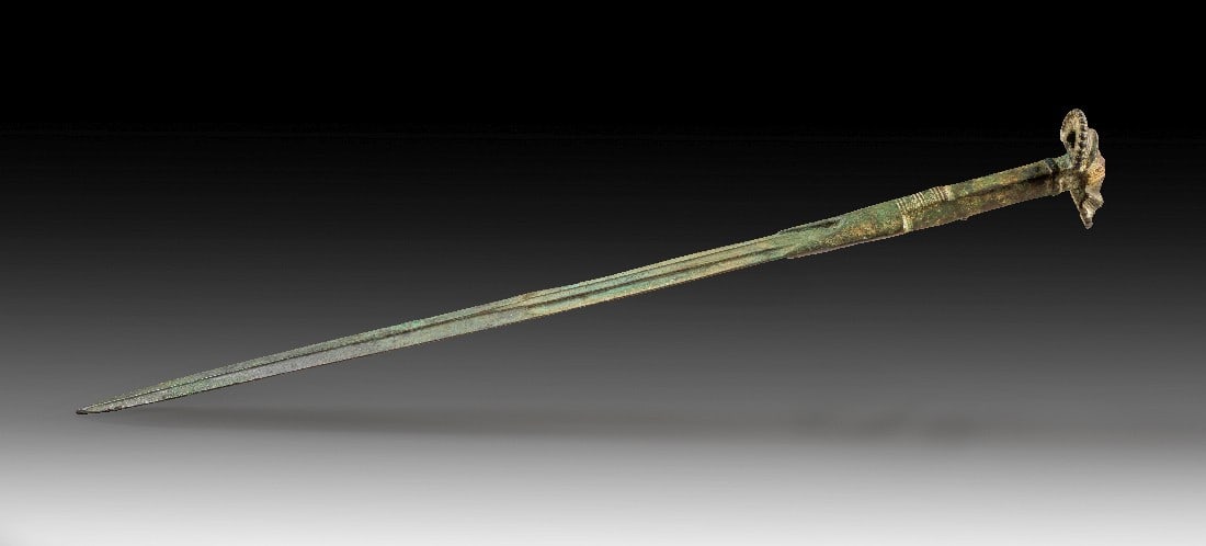 Bronzenes Schwert mit Fächergriff.: Bronzenes Schwert mit Fächergriff. Luristan, Anfang 1. Jt. v. Chr. L 62,5cm. Vollguss. Der Griff ist an der Schneide angegossen und vierkantig. Die Kontur zwischen Schneide und Ansatzstück ist