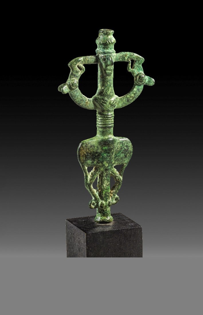 Standarte Herr der Tiere .: Standarte "Herr der Tiere". Luristan, 8. - 7. Jh. v. Chr. H 14,2cm. Bronzeguss. Zentrale Röhre mit Januskopf und Händepaar, seitlich zwei Tiere. Schöner Stil! Grüne Patina, intakt, mit