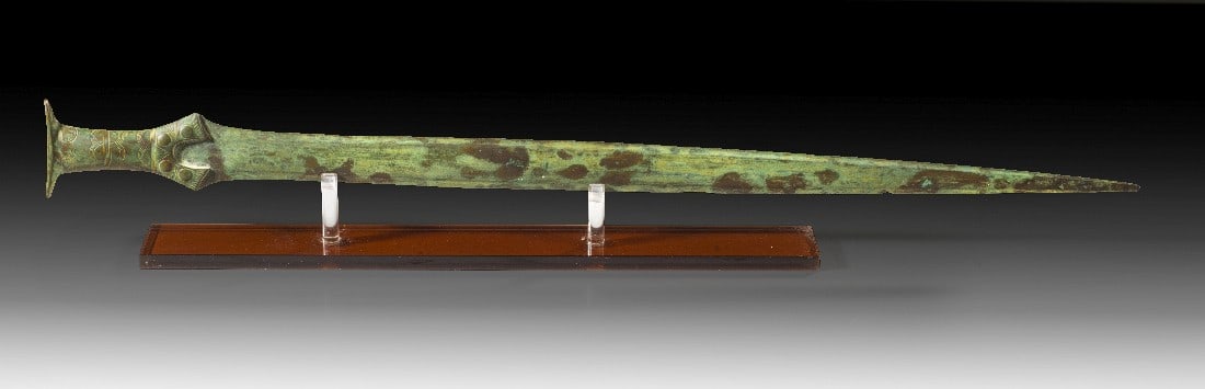 Vollgriffschwert Typ Spatzenhausen.: Vollgriffschwert Typ Spatzenhausen. Mittlere Bronzezeit, 15. - 14. Jh. v. Chr. L 66,2cm, B Knauf 6,1cm und Klinge 3,1cm. Bronzevollguss. Beidseitig vierfach genietet, auf Griffstange und Knauf