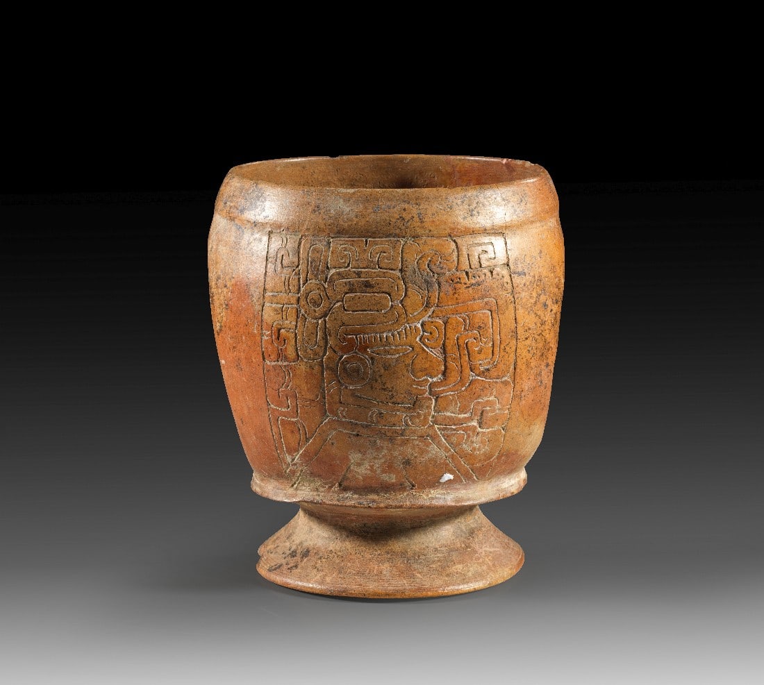 Becher mit Ritzdekor.: Becher mit Ritzdekor. Maya, ca. 550 - 950 n. Chr. Späte Phase, toltekischer Einfluss. H 17,5cm, ø 15cm. Dünnwandiges Gefäß mit Standfuß und eingedellten Seiten, mit sog.