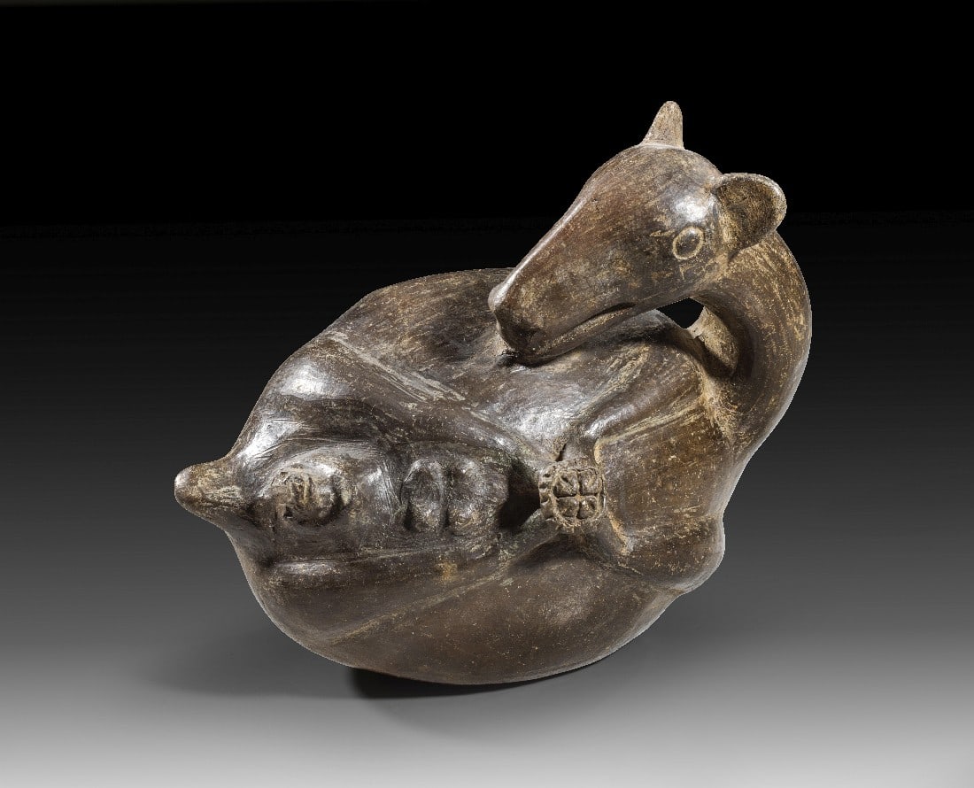 Lama.: Lama. Chimú, ca. 1300 - 1500 n. Chr. H 15,5cm, L 20cm. Grauschwarzer Ton. Gefäß in Form eines gefangenen, weiblichen Lamas mit zusammengebundenen Beinen im Moment der Geburt. Intakt. Provenienz: