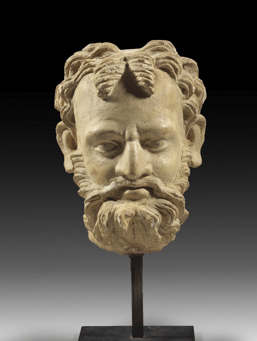 Ghandara Steinkopf eines bärtigen Bodhisattva oder Weisen.: Ghandara Steinkopf eines bärtigen Bodhisattva oder Weisen. Nordwestindien, 2.-4. Jh. n. Chr. H ca. 18cm, H ca. 26cm (mit Sockel). Hellbeiger Sandstein, modern gesockelt. Mit Farbresten. Vollplastisch