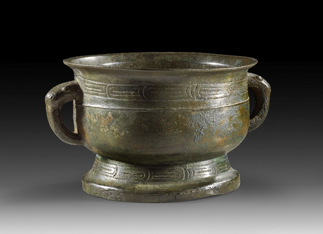 Bronzenes Speiseopfergefäß vom Typ Kuai.: Bronzenes Speiseopfergefäß vom Typ Kuai. China, westliche Zhou-Dynastie, ca. 9 Jh. v. Chr. H 15,4cm, ø 23,5cm. Bronze, fein gegossen mit dunkelgrüner bis rötlichbrauner Patina. Breiter