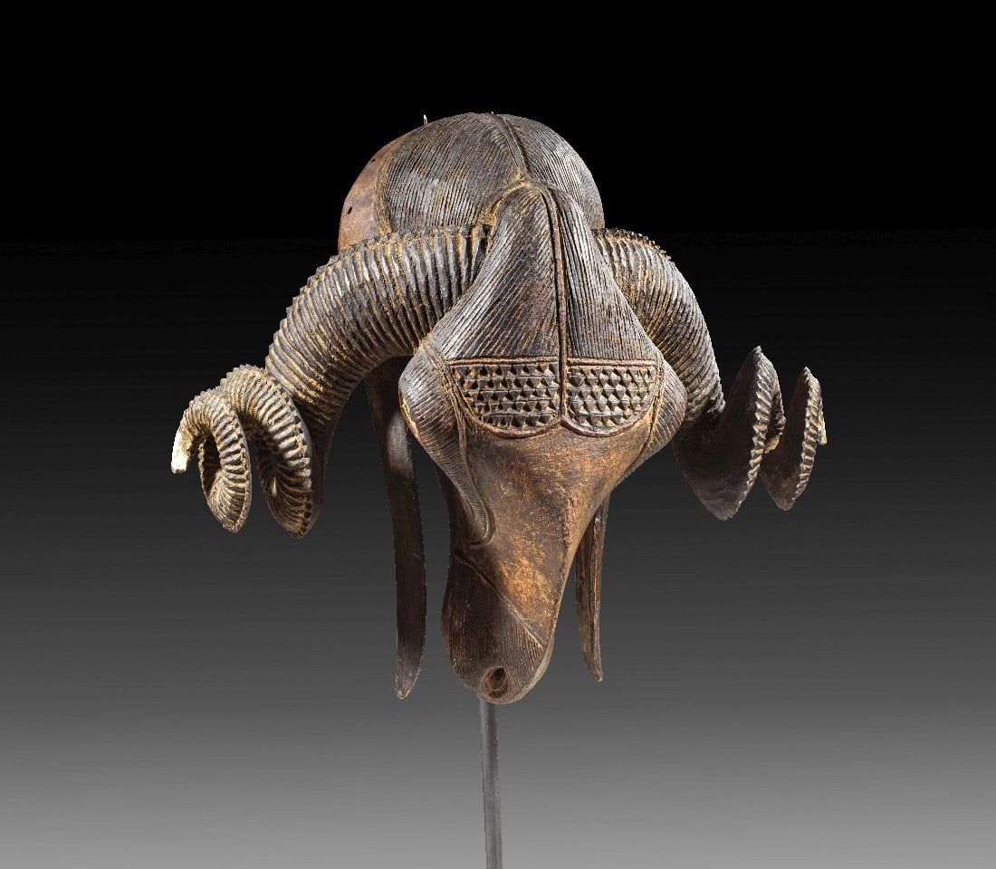 Widdermaske.: Widdermaske. Elfenbeinküste, Baule, 2. Hälfte 20. Jh. Gesamthöhe mit Sockel 51,5cm, H Maske 33cm, B 39cm. Holz. Augen weiß gefärbt. Beschnitzt mit Riefel- und Liniendekor sowie Dreiecksmuster.