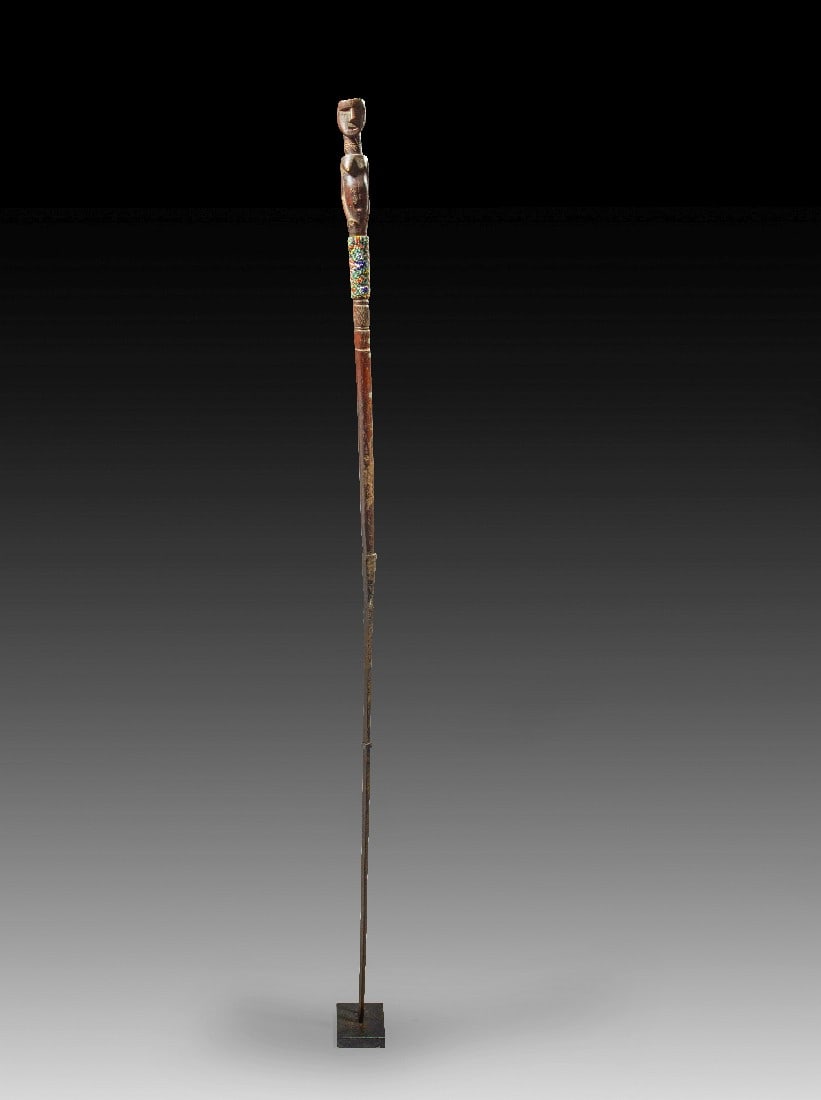 Zeremonialstab.: Zeremonialstab. Zentralöstliches Tansania, Luguru (oder Ngulu). H 148cm. Holz, Eisen, Glasperlen. Bekrönt von weiblicher Halbfigur aus Holz mit Skarifizierungen im Gesicht, am Hals, Bauch und