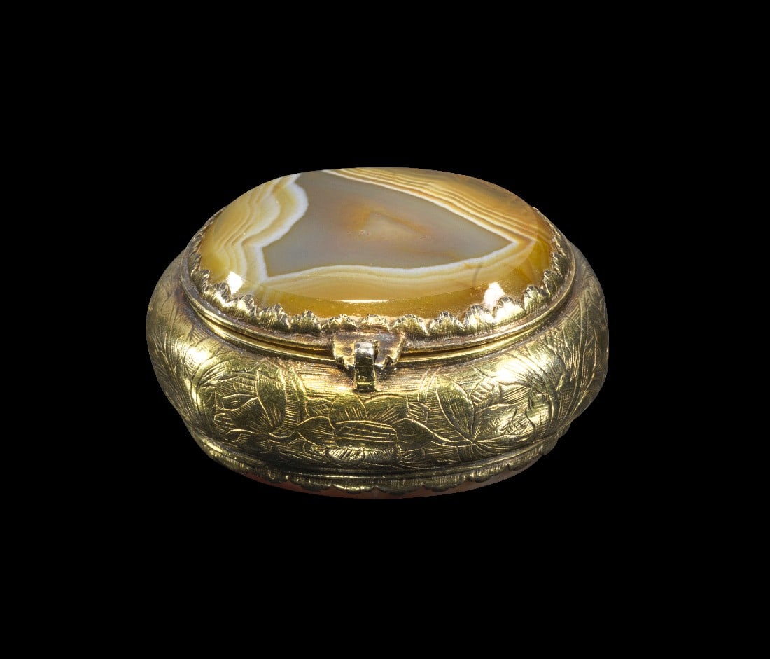 Schmuckkästchen mit doppelter Lagenachat-Gemme.: Schmuckkästchen mit doppelter Lagenachat-Gemme. Vermutlich Augsburg, 17. Jh. 4 x 3,2 x 2cm. Deckel und Boden aus Lagenachat, mit gravierten vergoldeten Silberbeschlägen. Auf dem Intaglio des