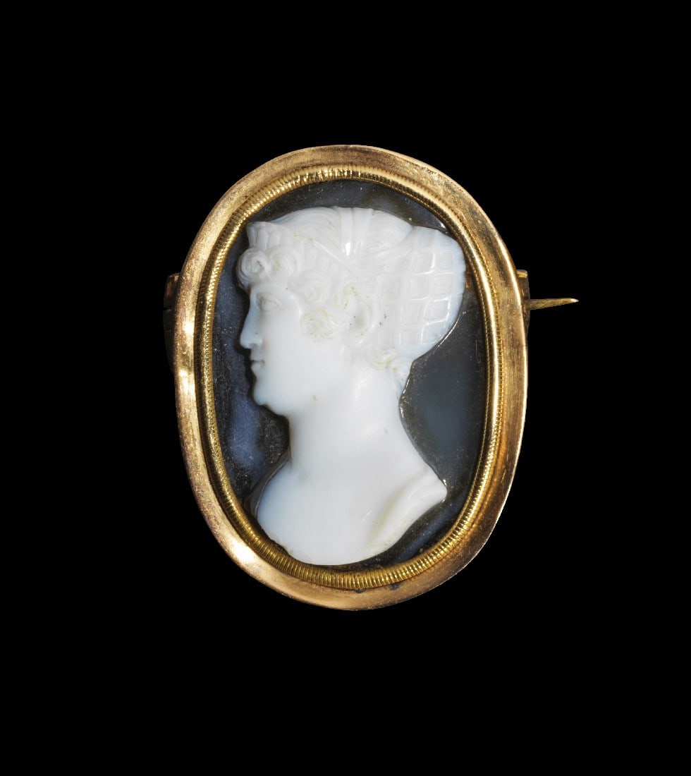 Brosche mit Onyx-Kameo.: Brosche mit Onyx-Kameo. Um 1800. 5,40g, H Brosche 3,1cm. Spätgeorgianische Goldbrosche, besetzt mit einem Onyx-Kameo-Porträt von Berini. Die markante Frisur erinnert an die große Kamee von Rossi