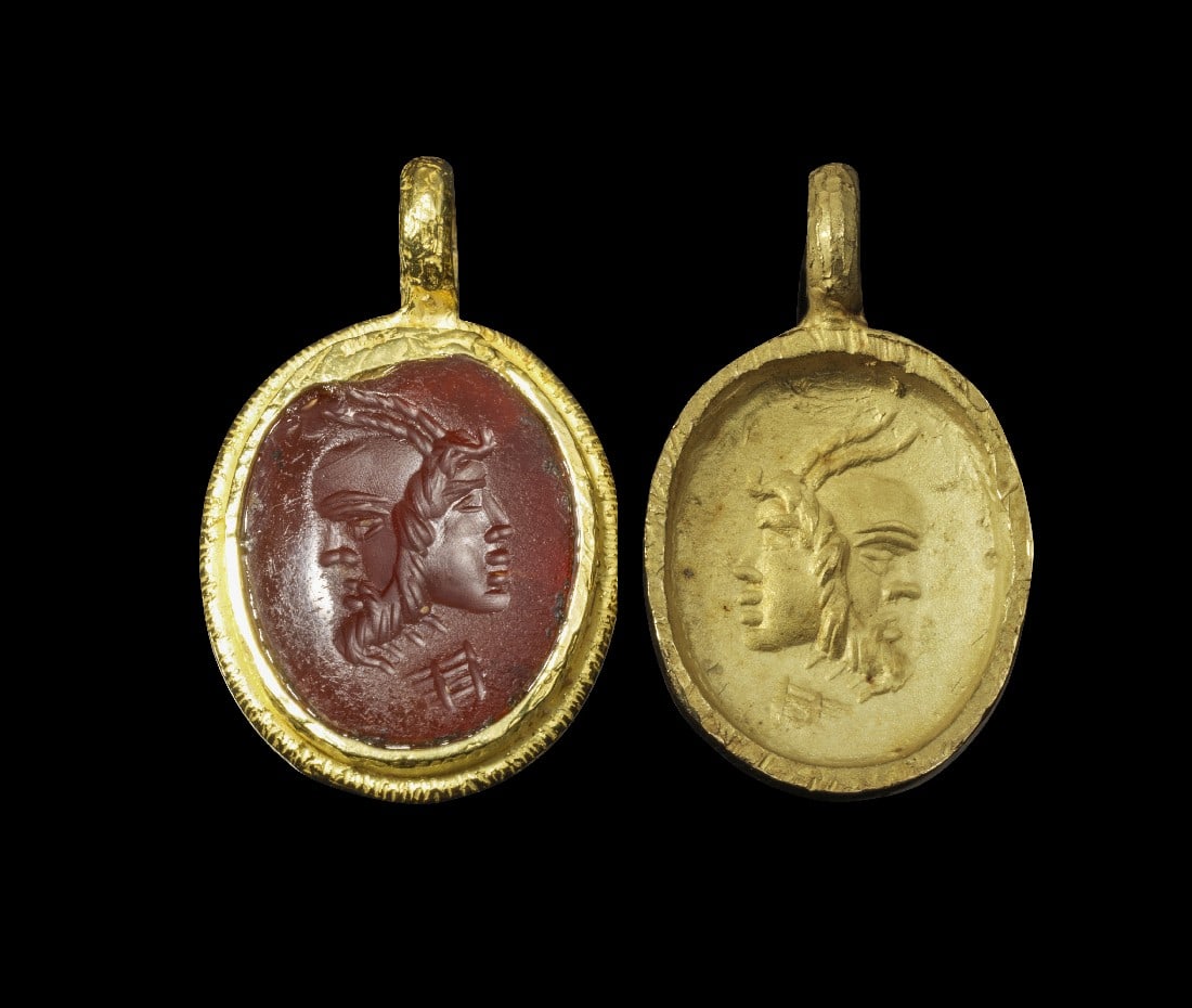 Zwei Goldanhänger, einer mit Gemme.: Zwei Goldanhänger, einer mit Gemme. Fassung und ein Anhänger modern, Gemme römisch, 2. - 3. Jh. n. Chr. 4,18g, L 2,5cm. In Gold gefasste Gemme aus rotem Karneol. Auf dem Intaglio ein Gryllos aus de