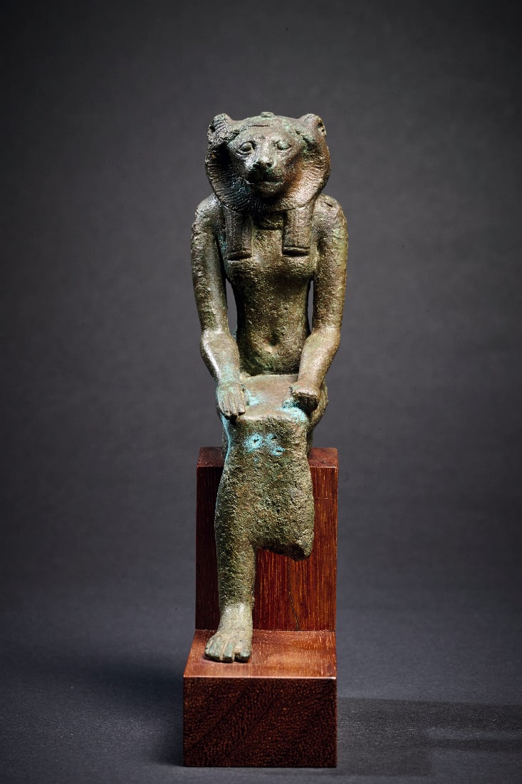 Statuette der Goettin Sachmet.: Statuette der Goettin Sachmet. Spaetzeit, 26. - 30. Dynastie, 664 - 343 v. Chr. Bronzevollguss, H 12cm. Sitzende Goettin in langem Gewand und mit Loewenkopf, hinter dem die dreigeteilte Peruecke hervo