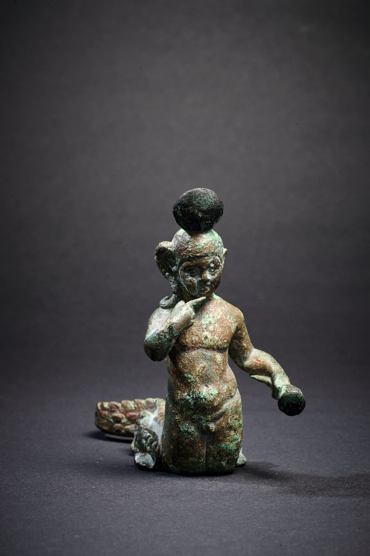 Harpokrates mit Krokodilskoerper.: Harpokrates mit Krokodilskoerper. Roem. Kaiserzeit, 2. Jh. n. Chr. Bronzehohlguss. H 9cm L 11,5cm. Der Koerper des kindlichen Gottes geht an der Huefte in einen geschlaengelten Krokodilskoerper