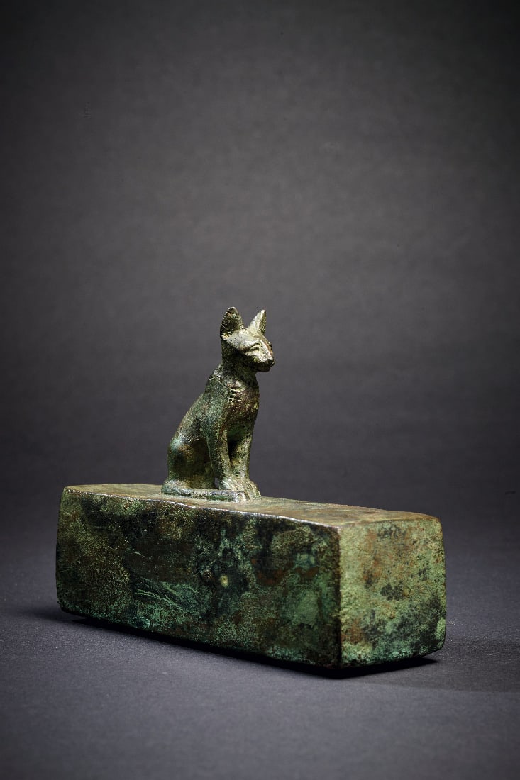 Miniatur-Sarkophag mit Katze.: Miniatur-Sarkophag mit Katze. Spaetzeit bis Ptolemaeische Periode, ca. 664 - 30 v. Chr. L 11cm, B 8,7cm. Bronzevollguss. Quaderfoermige Box, auf der eine Katze sitzt. Hintere Schmalseite geoeffnet,