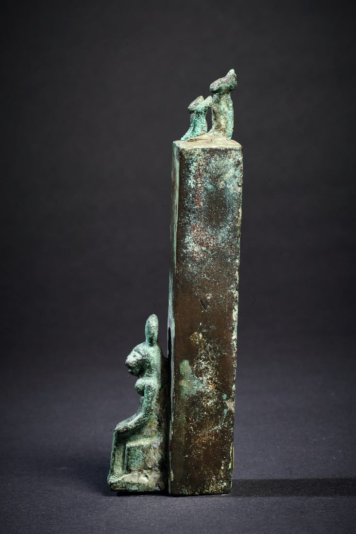 Votivpfeiler mit Katzen.: Votivpfeiler mit Katzen. Saitenzeit, ca. 600 v. Chr. H 10,5cm. Vor dem Pfeiler thronende Katzengoettin, auf der Spitze drei hockende Kaetzchen. Gruene Patina, intakt. Provenienz: Ex Sammlung Erwin Opp