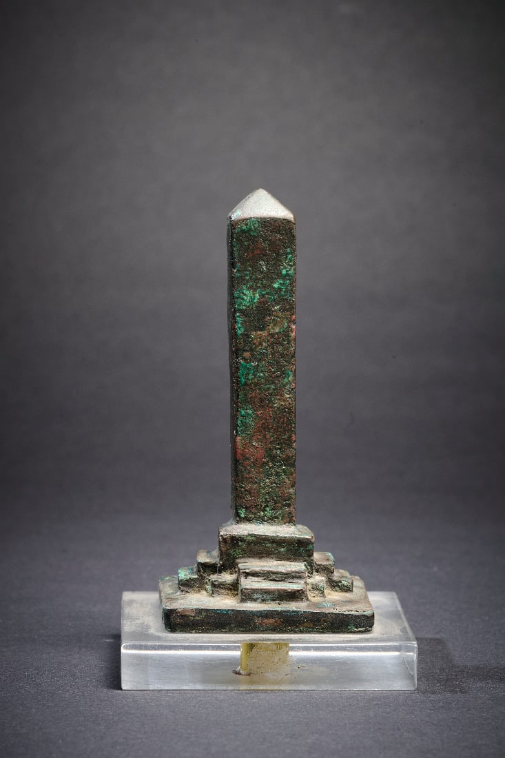 Obelisk.: Obelisk. Spaetzeit, ca. 711 - 323 v. Chr. Bronzevollguss. H 9,3cm. Auf einer quaderfoermigen Basis, zu der auf jeder Seite Stufen fuehren. Rotbraune Patina, intakt. Provenienz: Ex Sammlung Erwin