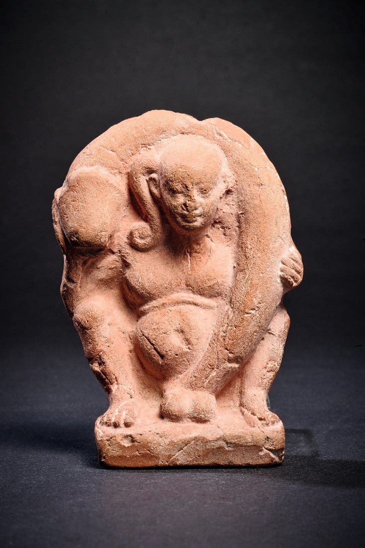 Harpokrates mit Phallus.: Harpokrates mit Phallus. Romano-aegyptisch, 1. - 3. Jh. n. Chr. Hellrote Terracotta einseitig ausgeformt, H 11,5cm. Breitbeinig hockender, fuelliger Knabe mit Jugendlocke schlingt seinen Phallus um