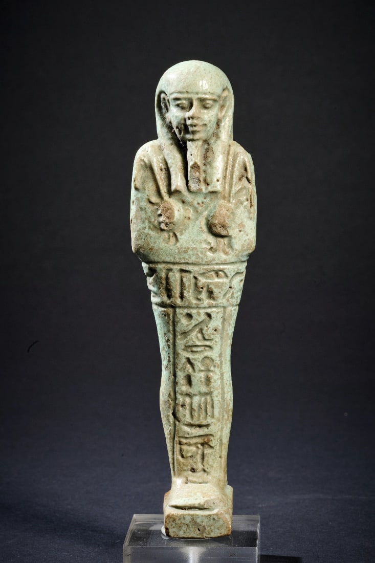 Uschebti.: Uschebti. Spaetzeit, 30. Dynastie, 380 - 342 v. Chr. H 14,2cm. Tuerkise Fayence. Mumienfoermig mit dreigeteilter Peruecke, Bart und Hacke und Pflug, rueckwaertig Pfeiler. Auf der Vorderseite