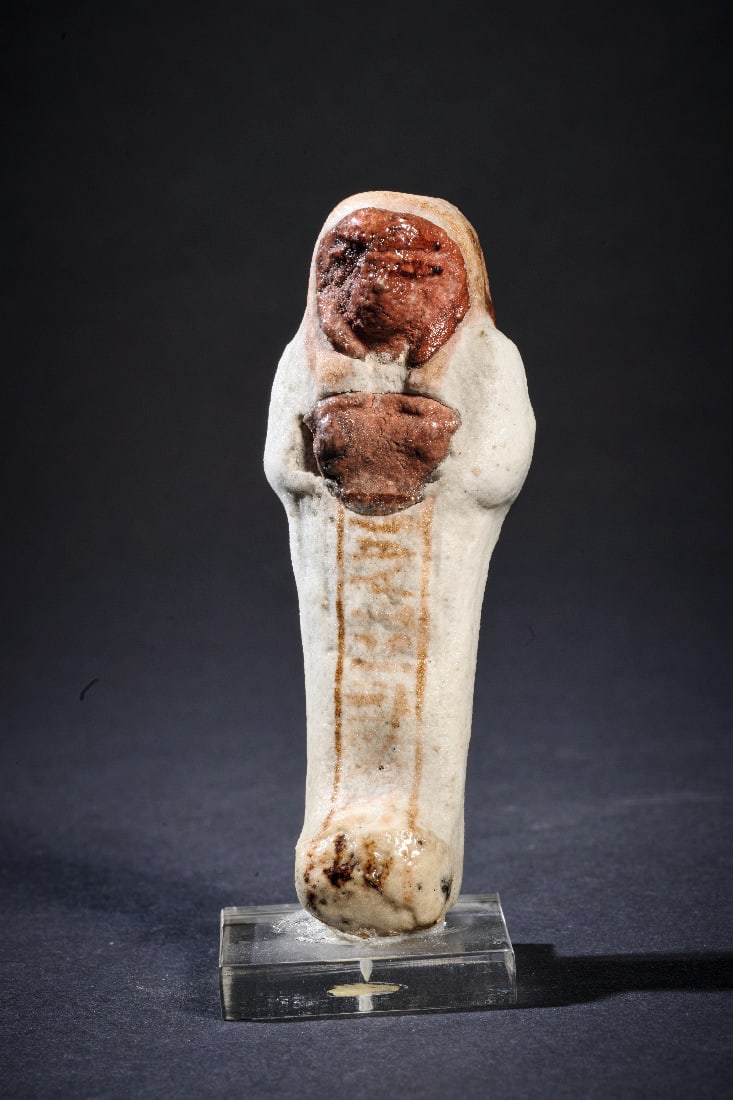 Bunter Uschebti eines Priesters.: Bunter Uschebti eines Priesters. Neues Reich, 19. - 20. Dynastie, 1292 - 1070 v. Chr. H 8,4cm. Mumienfoermiger Koerper mit vertikalem Hieroglyphenband. Das Gesicht, die Haende und die Peruecke sind