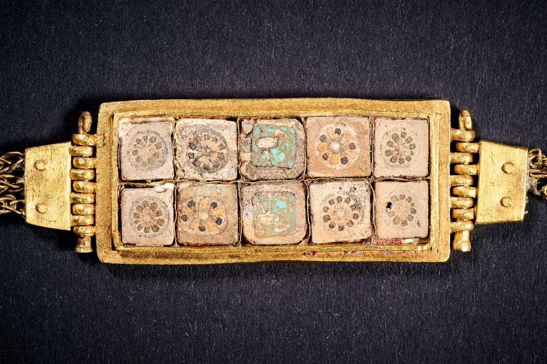 Goldarmband mit Millefioriglaseinlagen.: Goldarmband mit Millefioriglaseinlagen. Ptolemaeerzeit, ca. 330 - 30 v. Chr. L 20,8cm. 44g. Flaches Flechtband mit Verschluss haelt eine rechteckige Fassung, die mit zwei Reihen von jeweils fuenf