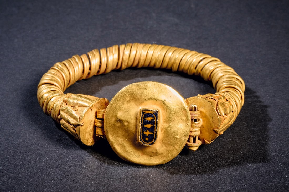Goldener Armreif mit Kartusche des Pharaos Pije (Pianchi).: Goldener Armreif mit Kartusche des Pharaos Pije (Pianchi). 25. Dynastie, 744 - 656 v. Chr. 45,08g, ? 7,5cm. Spiralarmband mit Enden, auf denen Palmblaetter aus Goldfolie aufgeloetet sind. Zentral ein