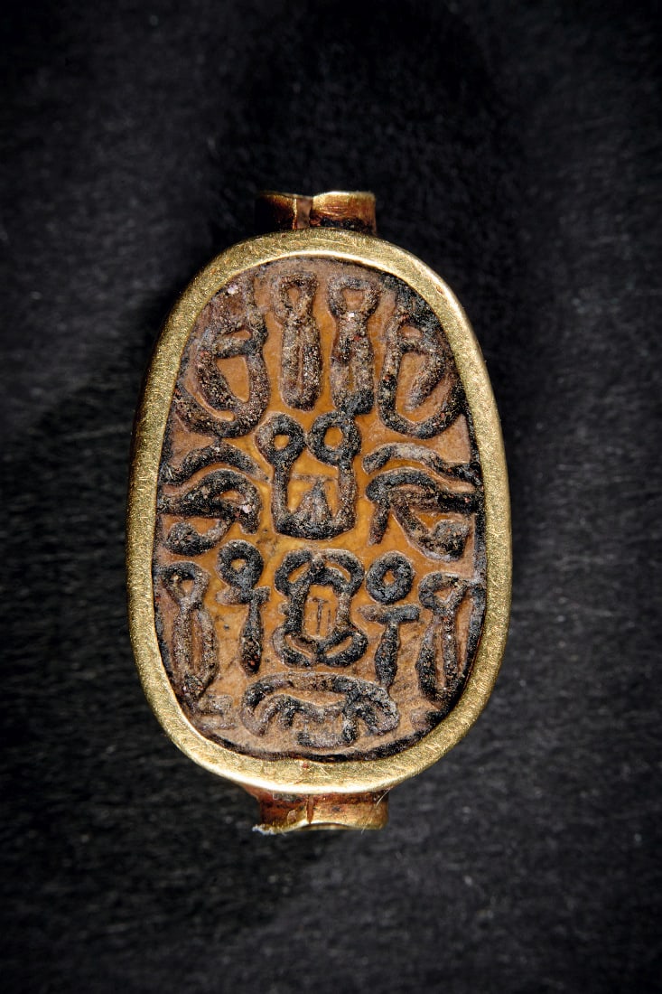 Mittelteil eines Goldrings mit Steatit.: Mittelteil eines Goldrings mit Steatit. Spaetes Mittleres Reich, 1600 v. Chr. 2,48g, H 2cm. Von Goldblech ummantelter brauner Steatit mit Hieroglyphen-Text. Mittelteil eines Ringes. Gold! Fragment,