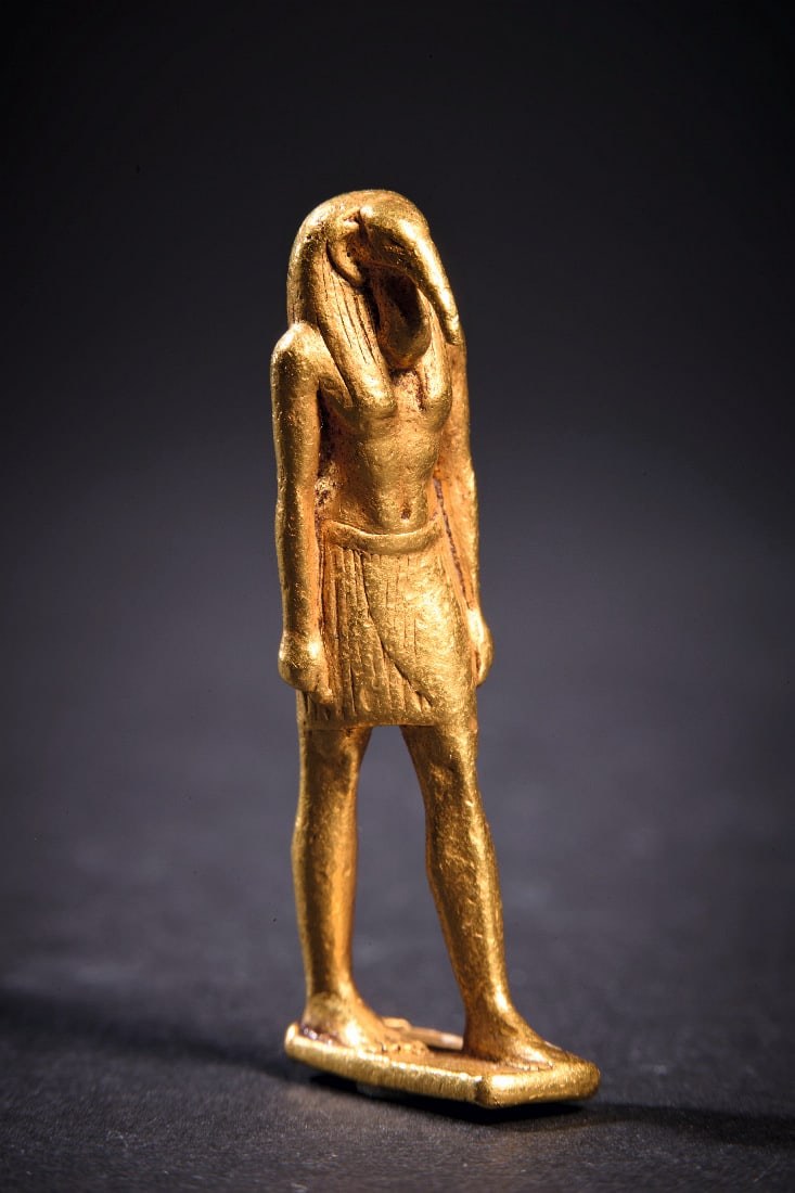 Goldener Amulett-Anhaenger in Gestalt von Thot.: Goldener Amulett-Anhaenger in Gestalt von Thot. Neues Reich, 1500 - 1200 v. Chr. 19,72g, H 4cm. Massive Goldstatuette des ibiskoepfigen Gottes Thot mit Peruecke und gefaelteltem Lendenschurz auf recht