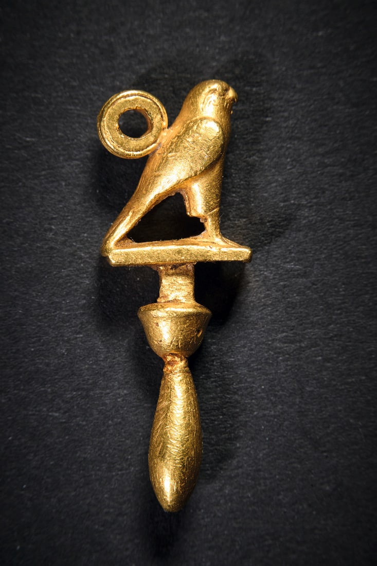 Goldanhaenger mit Horusfalke auf Papyruszepter.: Goldanhaenger mit Horusfalke auf Papyruszepter. Neues Reich, 18. Dynastie, um 1400 v. Chr. 9,94g, L 3,5cm. Horus-Falke mit oese auf dem Ruecken auf einer rechteckigen Basis, an der ein Papyrus-Zepter 