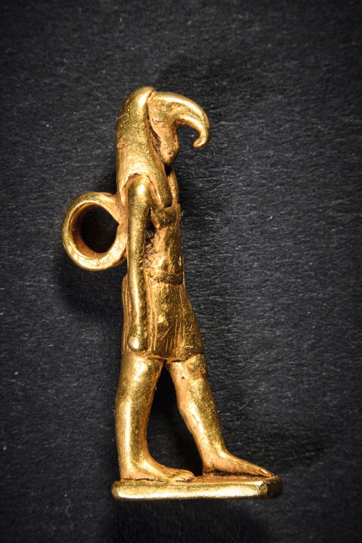 Goldener Amulett-Anhaenger in Gestalt von Thot.: Goldener Amulett-Anhaenger in Gestalt von Thot. Neues Reich, um 1200 v. Chr. 6,75g, H 2,8cm. Massive Goldstatuette des ibiskoepfigen Gottes Thot mit Peruecke und gefaelteltem Lendenschurz auf rechteck