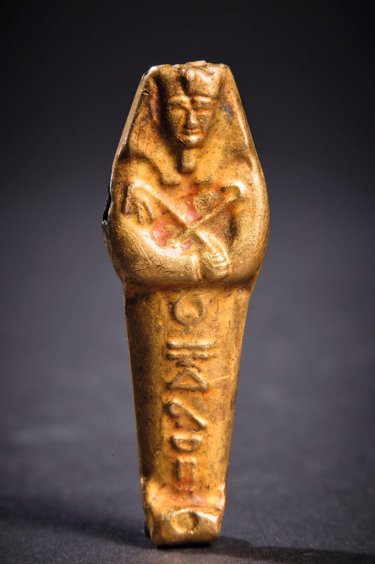 Ushebti-Amulett aus Gold.: Ushebti-Amulett aus Gold. Spaetzeit - Ptolemaeisch, 664 - 30 v. Chr. 7,65g, L 4,2cm. Auf der glatten Rueckseite eine oese. Die Vorderseite gestaltet als mumienfoermige Gestalt mit Kopftuch,