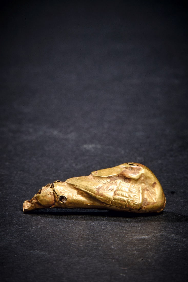 Goldene Miniatur-Ente.: Goldene Miniatur-Ente. Neues Reich, 18. Dynastie, 1550 - 1295 v. Chr. 1,75g, L 3,2cm. Aus graviertem Goldblech. Ente mit zurueckgewandtem Kopf in Schlafposition. Am hinteren Ende eine Durchbohrung