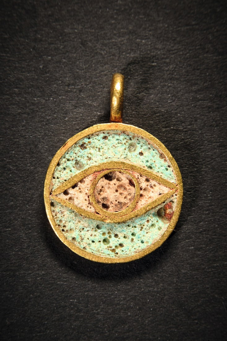 Goldanhaenger mit Auge.: Goldanhaenger mit Auge. Hellenistisch, Olbia (?), 3. - 1. Jh. v. Chr. 2,29g, L 2cm. Runder Anhaenger mit oese, im Inneren ein Auge mit Pupille aus Goldblech, das mit weisser und beiger Glaspaste