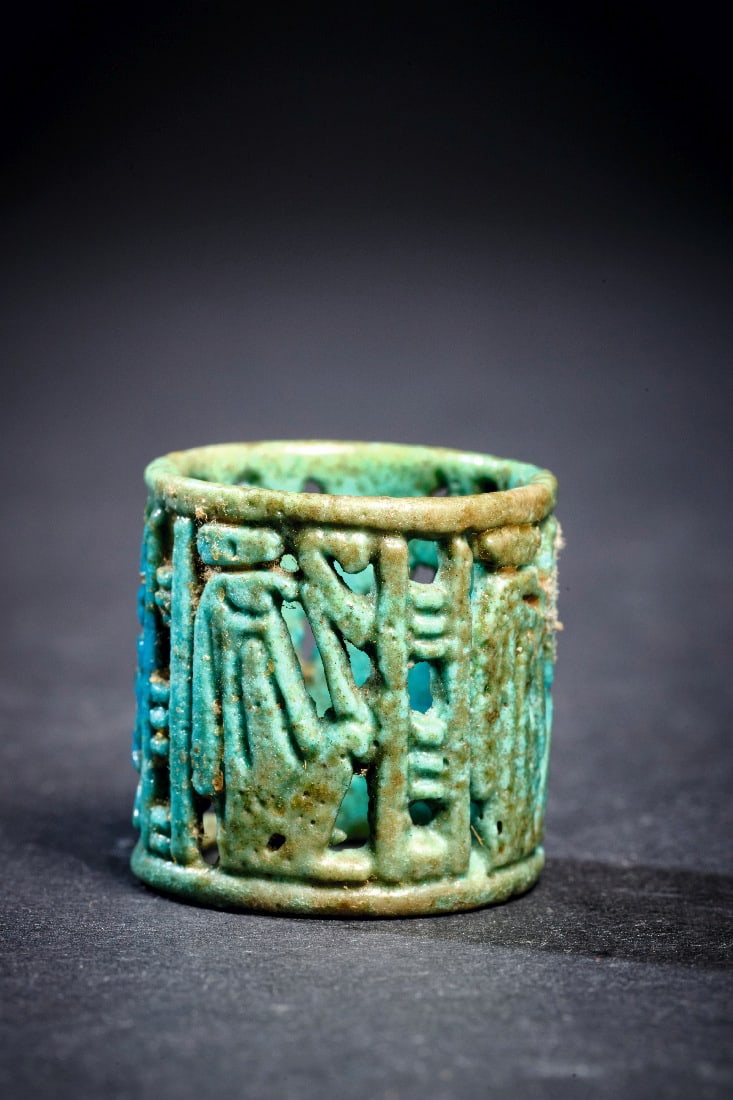Fayence-Ring.: Fayence-Ring. Neues Reich, 18. Dynastie, 1550 - 1295 v. Chr. B 2,2cm. Ringgroesse 55-58. Aus tuerkis glasierter Fayence in Durchbruchstechnik. Vier Figuren durch schmale Register getrennt. Intakt.