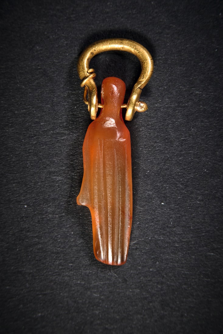 Amulettanhaenger in Form einer Hand.: Amulettanhaenger in Form einer Hand. Altes Reich, ca. 2465 - 2100 v. Chr. L 3cm. Aus Karneol, mit Goldoese. Intakt. Provenienz: Ex Sammlung Pierre Mavrogordato (1870 - 1948), seit 1943 in der