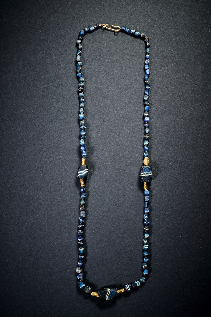 Kette aus Glas- und Goldperlen.: Kette aus Glas- und Goldperlen. Roemisch, 1. Jh. v. - 1. Jh. n. Chr. L 65cm. Aus quaderfoermigen Perlen aus blau-weiss gestreiftem Glas und kreuzfoermigen Perlen aus Goldblech. Tragbar! Modern