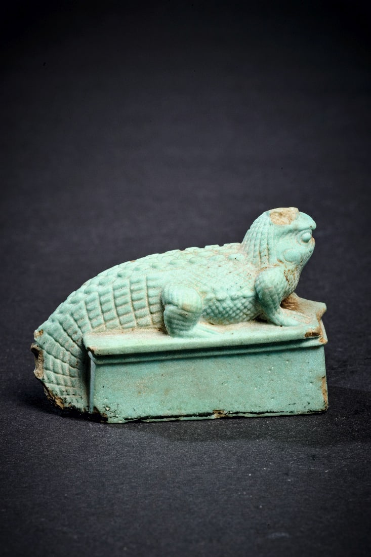Krokodil mit Horuskopf.: Krokodil mit Horuskopf. Neues Reich, 18. Dynastie, 1550 - 1295 v. Chr. L 5,5cm, B 2,5cm, H 4cm. Aus hellgruener Fayence. Das Krokodil liegt auf einer rechteckigen Basis und repraesentiert den Gott
