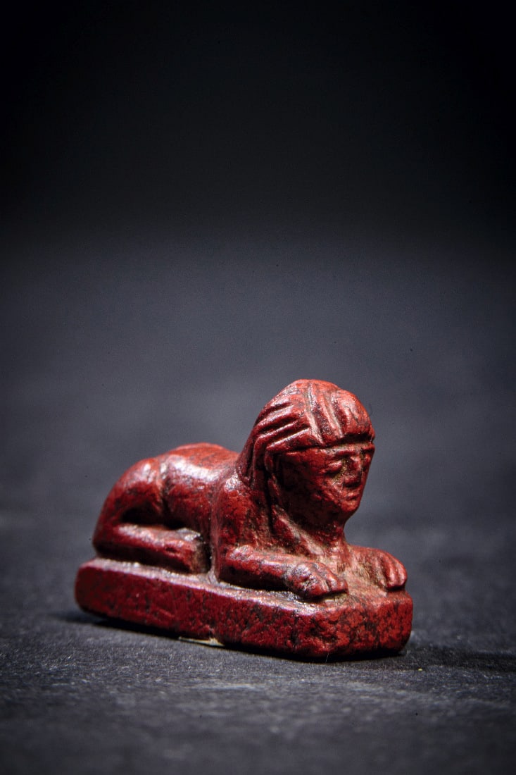 Statuette einer liegenden Sphinx.: Statuette einer liegenden Sphinx. Spaetzeit - Ptolemaeisch, 664 - 30 v. Chr. L 2cm. Aus rotem Jaspis. Intakt. Provenienz: Ex Sotheby's London, Auktion 18.03.1957, Los 18, aus der Sammlung Freeth,