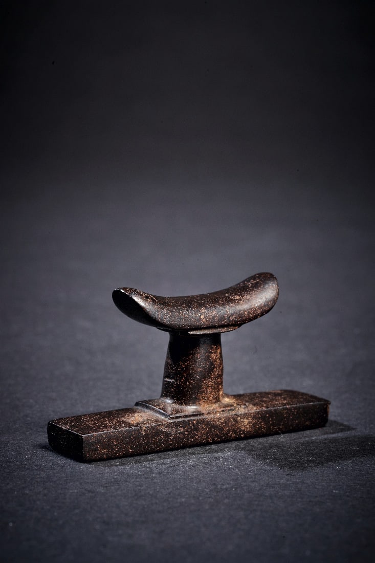 Miniatur-Nackenstuetze aus Haematit.: Miniatur-Nackenstuetze aus Haematit. Neues Reich, 1550 - 1070 v. Chr. B 5cm, H 2,5cm. Eine Ecke bestossen. Provenienz: Seit 1962 in der Sammlung Erwin Oppenlaender (1901 - 1988) und Nachfolger. Miniat